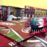 a woman in a white shirt is standing in front of a table with a picture of madonna