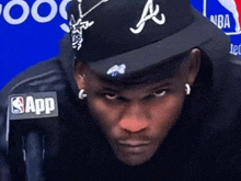 a man wearing a hat with the letter a on it looks at the camera