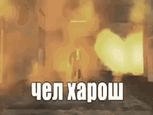 a person is standing in front of a building that is on fire and a explosion is going on in the background .
