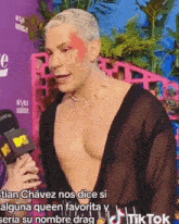 a shirtless man is being interviewed by a woman with a mtv microphone