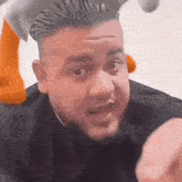 a man with a stuffed animal on his head is making a funny face