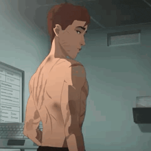 a man without a shirt is standing in front of a computer monitor .