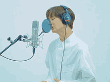 a man wearing sony headphones singing into a microphone