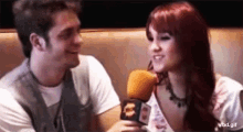 a man and a woman are sitting next to each other on a couch .