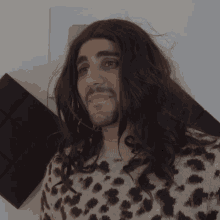 a man wearing a leopard print sweater has long hair