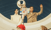 a man in a red nike hat is holding a colorful cube