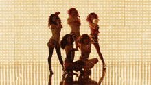 a group of women are dancing in front of a wall with lights on it