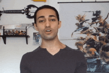 a man stands in front of a wall with a picture of a sword