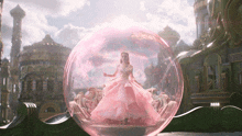 a woman in a pink dress is inside of a pink bubble