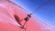 a man is riding a wave on a rope with the words viralhog written on the bottom