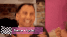 a man is holding a piece of paper that says bianca 1 point