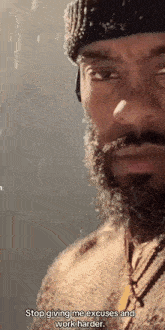 a man with a beard is wearing a beanie and a necklace and is talking about giving excuses and working harder