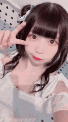 a girl with pigtails is giving the peace sign