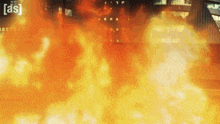 a large amount of fire is coming out of a building with the letters as visible in the corner