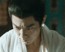a close up of a man 's face with a white shirt