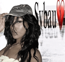 a woman wearing a hat is standing in front of a broken heart and the word syau