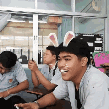a man wearing bunny ears and a cat face painted on his face