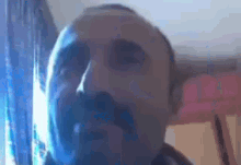 a close up of a man 's face with a mustache looking at the camera .