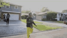 a man wearing a black shirt with the number 66 on it is walking down a street