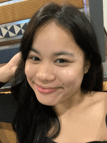 a close up of a woman 's face with a tile wall in the background