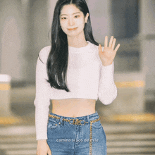 a woman wearing a white crop top and blue jeans says camina si sos de mile on the bottom