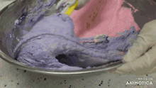 a person is mixing pink and purple frosting in a bowl