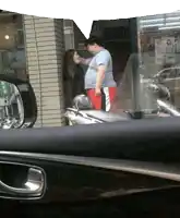 a man and a woman are standing in front of a store with a sign that says ' a ' on it
