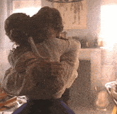 a man and woman are hugging in a living room .