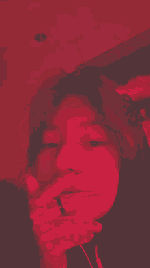 a woman is taking a picture of herself in a red light .