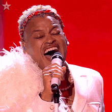 a man singing into a microphone with a star in the corner