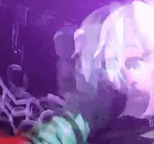 a close up of a person 's face in a purple light