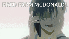 a man covering his face while talking on a cell phone with the words fired from mcdonald 's below him