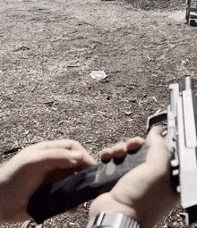 a person is holding a gun in their hands with a target in the background that says ' a ' on it