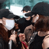 a woman wearing a ny hat talks to another woman