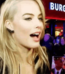 a woman with her mouth open in front of a burg restaurant