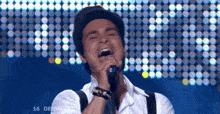 a man singing into a microphone with the number 16 on the bottom right