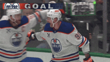 a hockey player celebrates a goal with another player