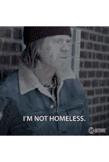 a man wearing a beanie and jacket says i 'm not homeless