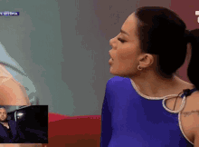 a woman in a blue leotard is sitting on a red couch in front of a screen that says ' sitepia '