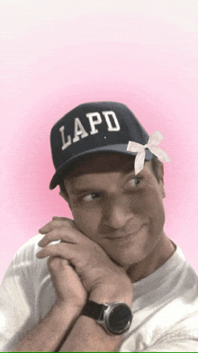 a man wearing a lapd hat with a pink bow on it