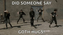 a group of men are dancing in front of a brick wall with the words did someone say goth hugs