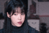 a close up of a woman 's face with a turtleneck