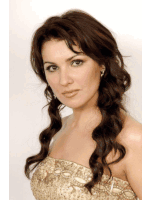 a woman with long dark hair is wearing a strapless gold dress