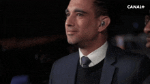 a man in a suit is holding a microphone that says canal +