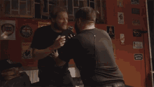 two men are fighting in front of a wall with a sign that says bosch on it