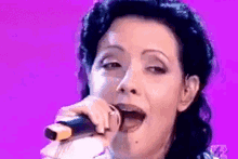 a close up of a woman singing into a microphone