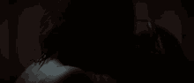 a woman 's back is visible in the dark