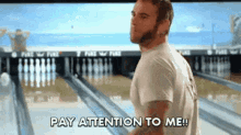a man standing in front of a bowling alley says " pay attention to me "