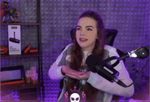a woman is sitting in front of a microphone .