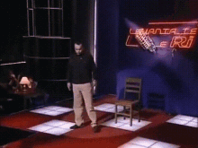 a man is standing on a stage in front of a microphone and a sign that says ' lemania ' on it